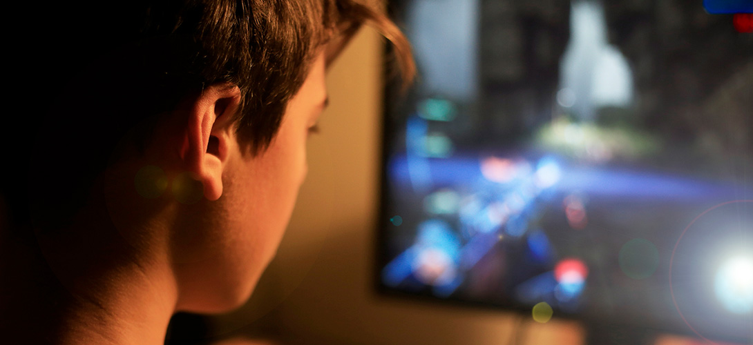 A photo of a boy looking at a blurred monitor. this is the article feature image.