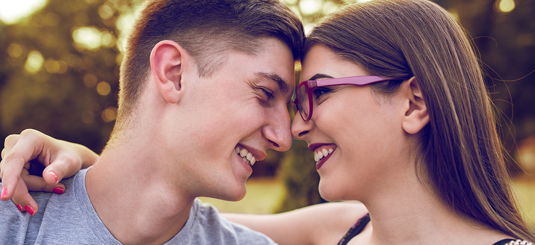 A young couple smiling and looking into each others eyes.
