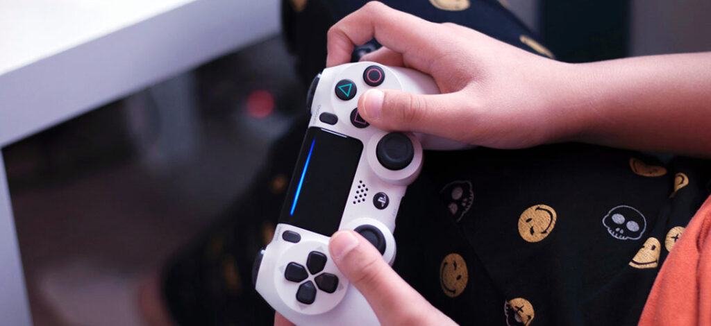 Close-up of a hands holding and playing with a playstation controller.