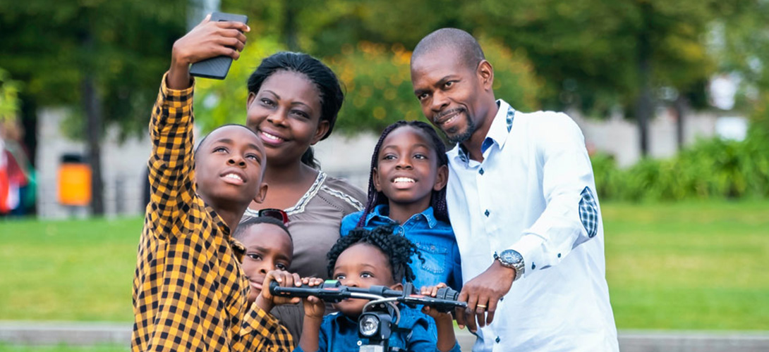Parents with their children taking a family selfie in a park.