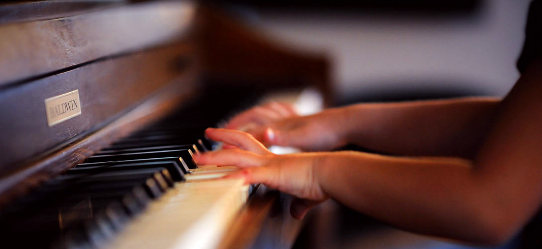 Close-up of a childs hands playing the piano.