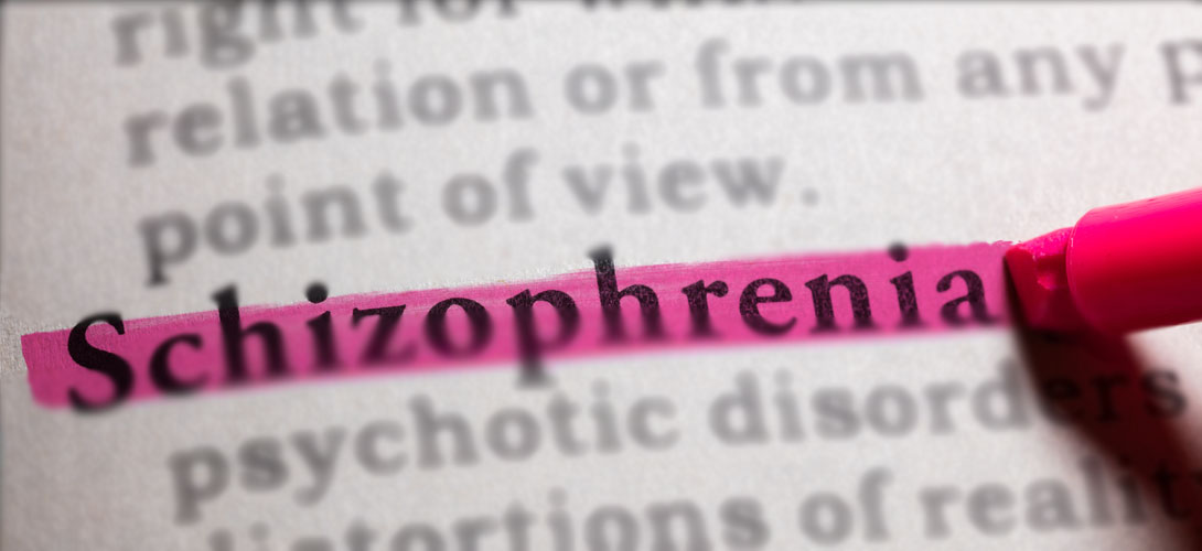 A close-up of a page the word schizophrenia is highlighted with a pink highlighting pen.